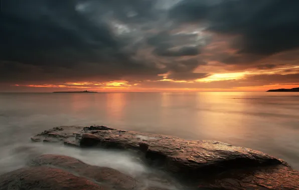 Картинка море, небо, закат, оранжевый, тучи, камни, берег, Англия, вечер, Великобритания, штиль